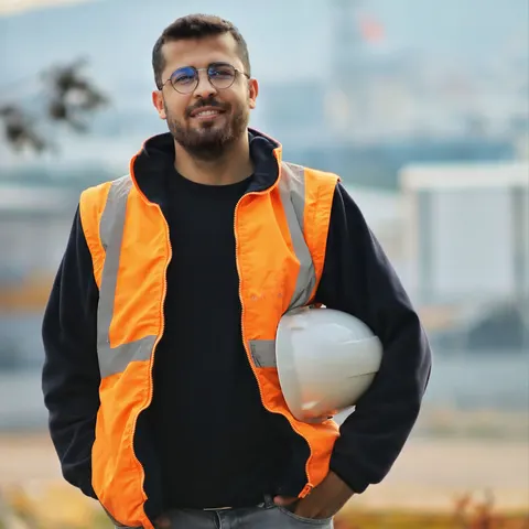 Contractor wearing a safety vest and holding a hard hat